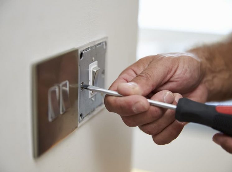 Removing screw from electrical plug — Electrical & Air-Conditioning in Helensvale, QLD